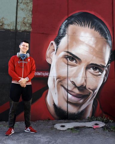 уличный художник рисует портрет знаменитого футболиста